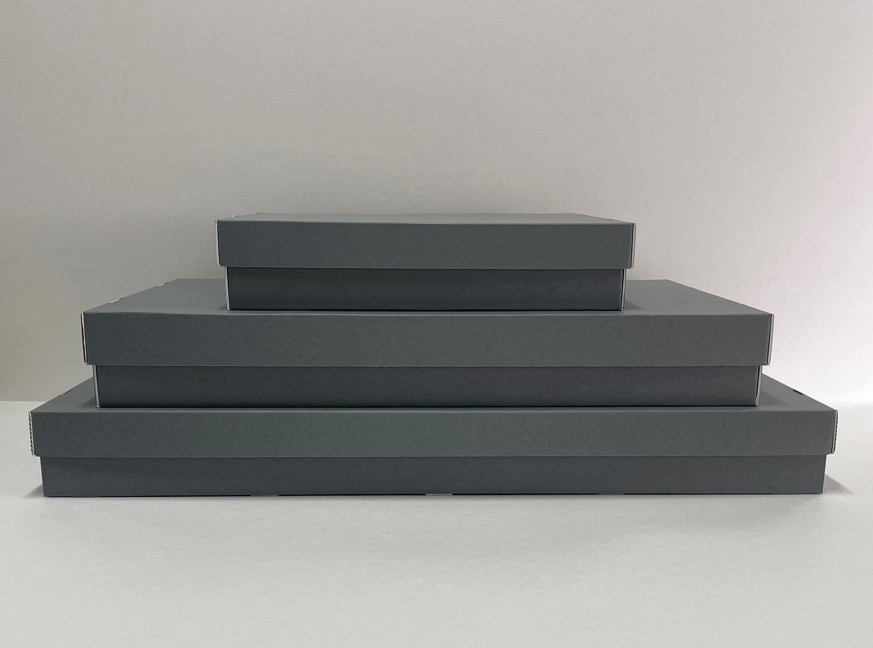 Stack of three gray fluted costume storage boxes made from Archival board